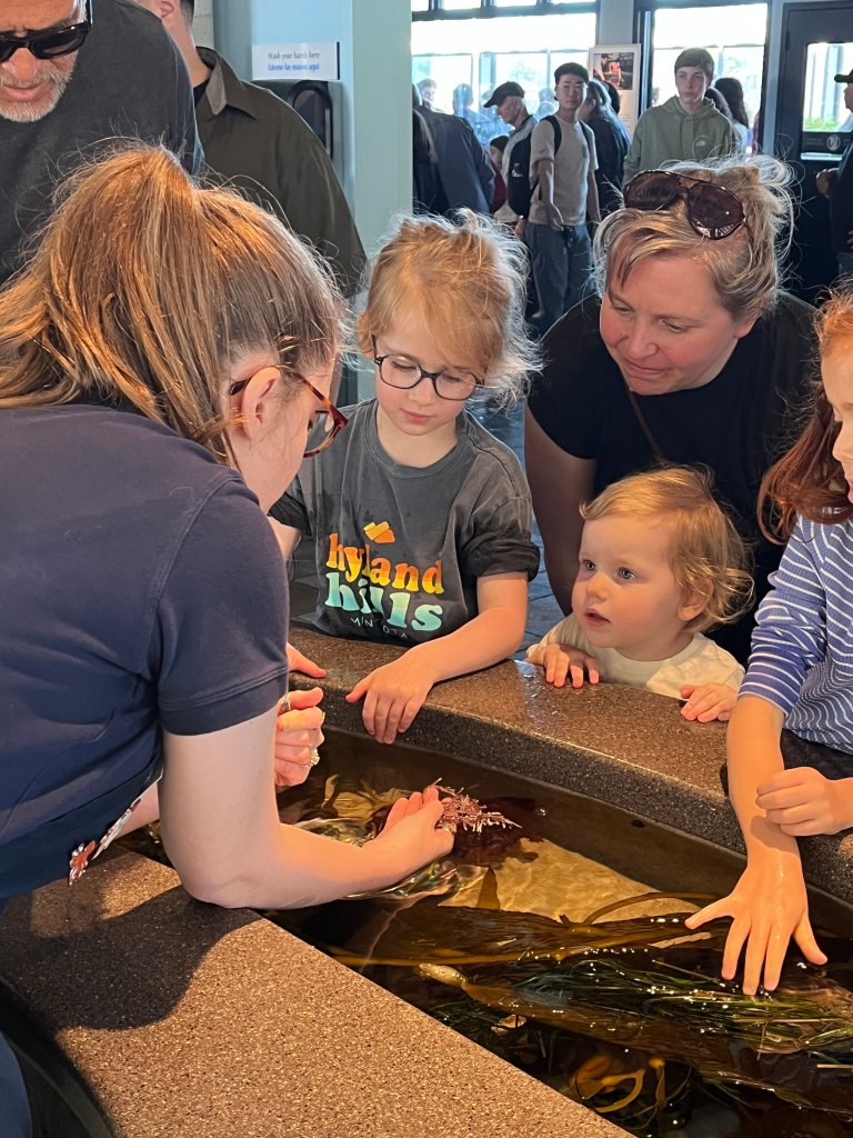 A photo of young children interacting with animals at an aquarium