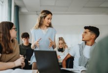 High school teacher talking to students about an assignment