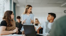 High school teacher talking to students about an assignment