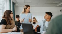 High school teacher talking to students about an assignment