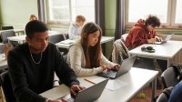 High school students working on laptops in class