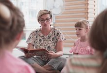 Elementary teacher reading a book to students