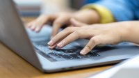 Student typing on a laptop