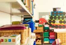 A clean preschool classroom with materials organized in bins and on top of shelves