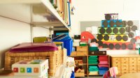 A clean preschool classroom with materials organized in bins and on top of shelves