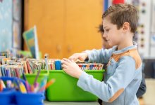 A child looking through a book bin in a classroom