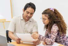 Teacher working 1:1 on a paper with middle or high school student