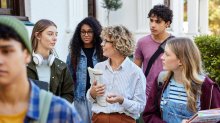 A teacher leading her class on a tour of a public area outside the school