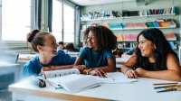 Middle school teacher working with two students