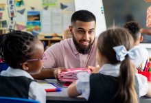 Preschool teacher talking to two students