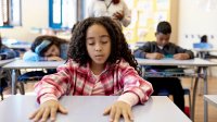 Elementary students participating in a breathing exercise