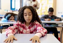 Elementary students participating in a breathing exercise