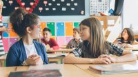 Two elementary students talking in class