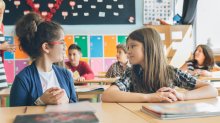 Two elementary students talking in class