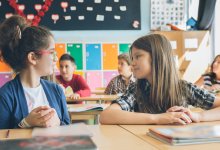 Two elementary students talking in class