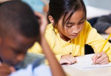 Elementary students drawing at their desks