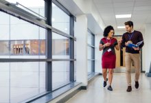 An administrator guiding a teacher around a school building