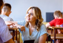 A teacher kneeling and talking calmly to a middle school student