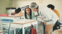 A teacher encouraging a shy student in class