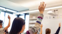 Middle school student raising her hand in class