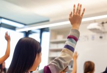 Middle school student raising her hand in class