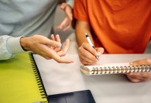 A teacher guiding a male middle school student through journaling practices