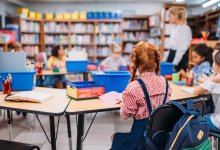 Elementary students sitting with art supplies in a school library