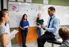 A teacher guiding high school students through a science-based skit