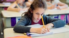 A classroom of elementary students writing in a journal