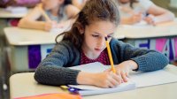 A classroom of elementary students writing in a journal