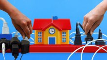 Hands unplugging an overloaded school-shaped power strip