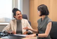 Two coworkers involved in a thoughtful discussion