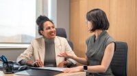 Two coworkers involved in a thoughtful discussion