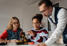 Teacher listening to students talk about a science project
