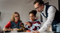 Teacher listening to students talk about a science project