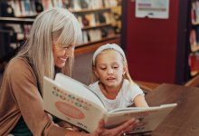 Adult reading to child in a library