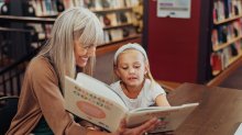 Adult reading to child in a library