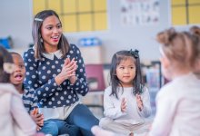 Preschool teacher leading students in a clapping exercise
