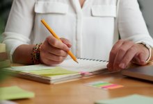 Adult making notes in a journal with sticky notes