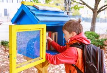 Child looking through books in a community free library