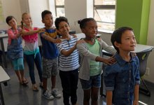 Elementary students participating in a drama game