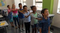 Elementary students participating in a drama game