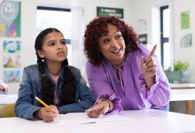 Teacher working with student at her desk