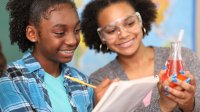 Two students recording the results of a science experiment in a notebook