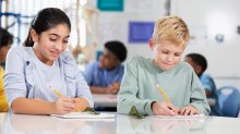 Middle school students writing in their notebooks during science class