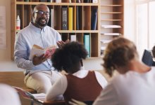 A high school teacher lecturing his students on a book