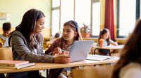 Elementary teacher working with student one-on-one