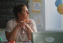 Teacher looking thoughtfully at an empty classroom