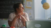 Teacher looking thoughtfully at an empty classroom