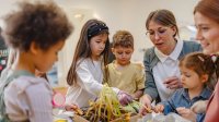 Preschool teacher working with students on a project